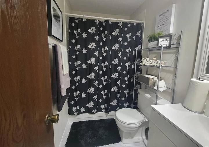 Original listing photo of the hall bathroom with a black floral shower curtain