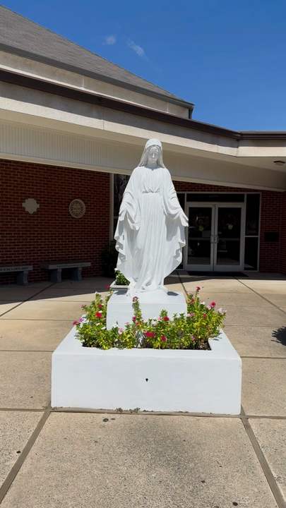 The opening shot: the statue of Our Lady at the church entrance, with flowers at its base